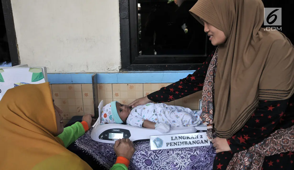 Petugas menimbang bayi saat pemeriksaan rutin kesehatan di Posyandu Ria Balita, Cipinang, Jakarta, Selasa (16/7/2019). Presiden Joko Widodo fokus pada kesehatan ibu hamil dan anak sebagai modal Indonesia menjadi negara maju di masa depan serta mencegah terjadinya stunting. (merdeka.com/IqbalNugroho)