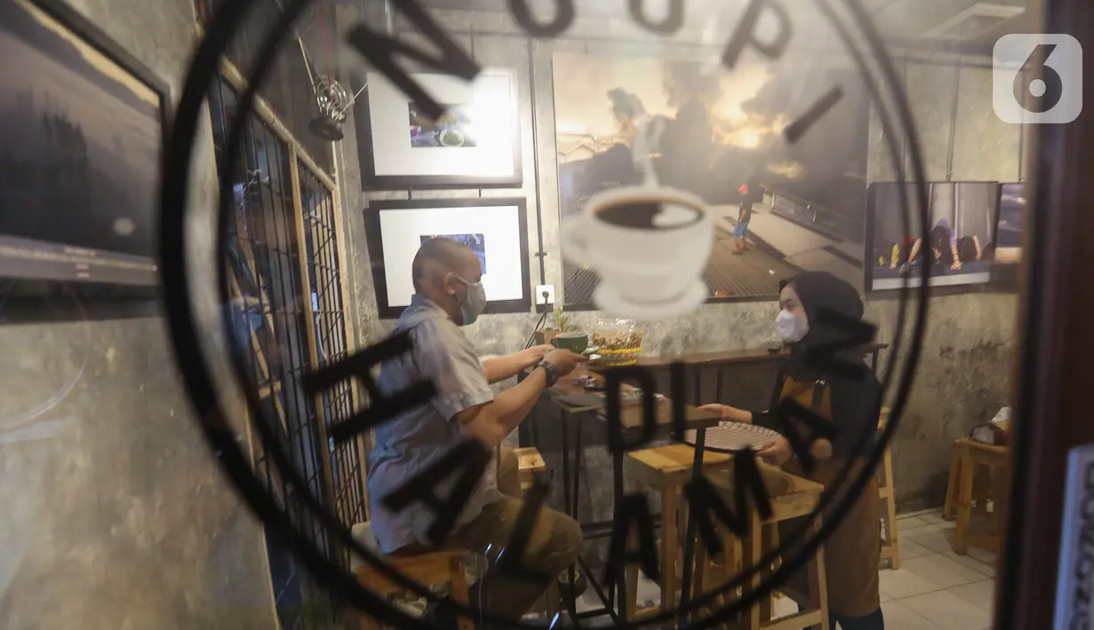 Pengunjung menikmati kopi di kedai Ngopi di Halaman Jalan Pulo Kamboja, Kebayoran Lama, Jakarta, Selasa (12/01/2021). Kedai yang buka pada hari Selasa - Minggu dari pukul 10.00 - 22.00 WIB juga menawarkan koleksi buku fotografi yang dibaca di tempat. (Liputan6.com/Fery Pradolo)