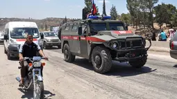 Mobil-mobil pemerintah dan kendaraan militer Rusia melintasi jalan raya utama antara Homs dan Hama di Suriah, Rabu (6/6). Pembukaan jalan itu dilakukan sebulan setelah pasukan Suriah merebut kembali wilayah kantong yang dikuasai militan itu (AFP/STRINGER)
