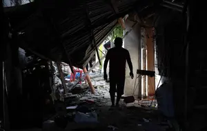 Warga berjalan melewati puing-puing rumah yang rusak akibat gempa di General Santos, Filipina, Selasa 9 Juni 2026. (AP Photo/Basilio Sepe)