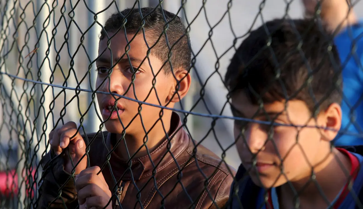 Bocah warga Palestina saat menonton pertandingan bola di lapangan futsal, Khan Younis, Jalur Gaza, (4/6). ). Meski negara tersebut mengalami berbagai konflik tetapi mereka tetap menghibur diri dengan bermain bola bersama. (REUTERS / Ibraheem Abu Mustafa)