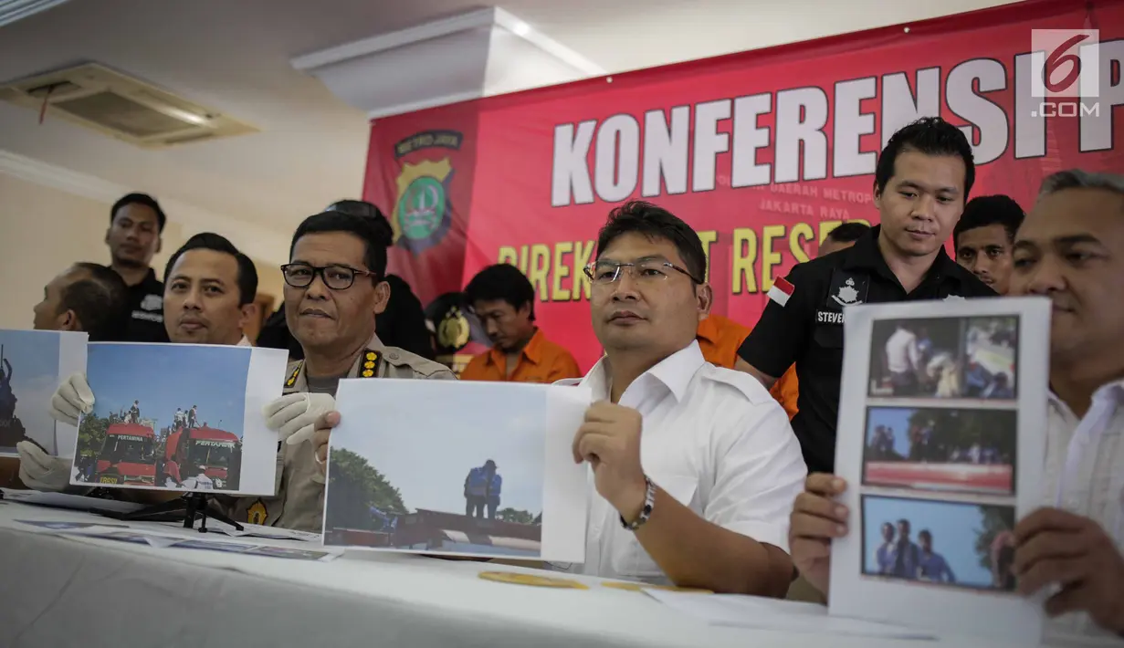 Kabid Humas Polda Metro Jaya Kombes Argo Yuwono didampingi jajaran menunjukkan foto kepada wartawan saat rilis pengungkapan tindak pidana perampasan truk tangki Pertamina di Polda Metro Jaya, Jakarta, Selasa (19/3). (Liputan6.com/Faizal Fanani)