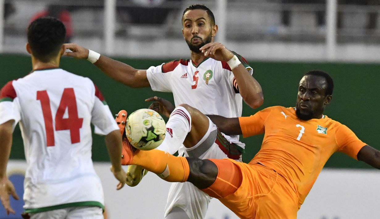 Striker Pantai Gading, Seydou Doumbia, berebut bola dengan bek Maroko, Medhi Benatia, pada Kualifikasi Piala Dunia 2018 di Stadion Félix Houphouët-Boigny, Abidjan, Sabtu (11/11/2017). Pantai Gading kalah 0-2 dari Maroko. (AFP/Issouf Sanogo)