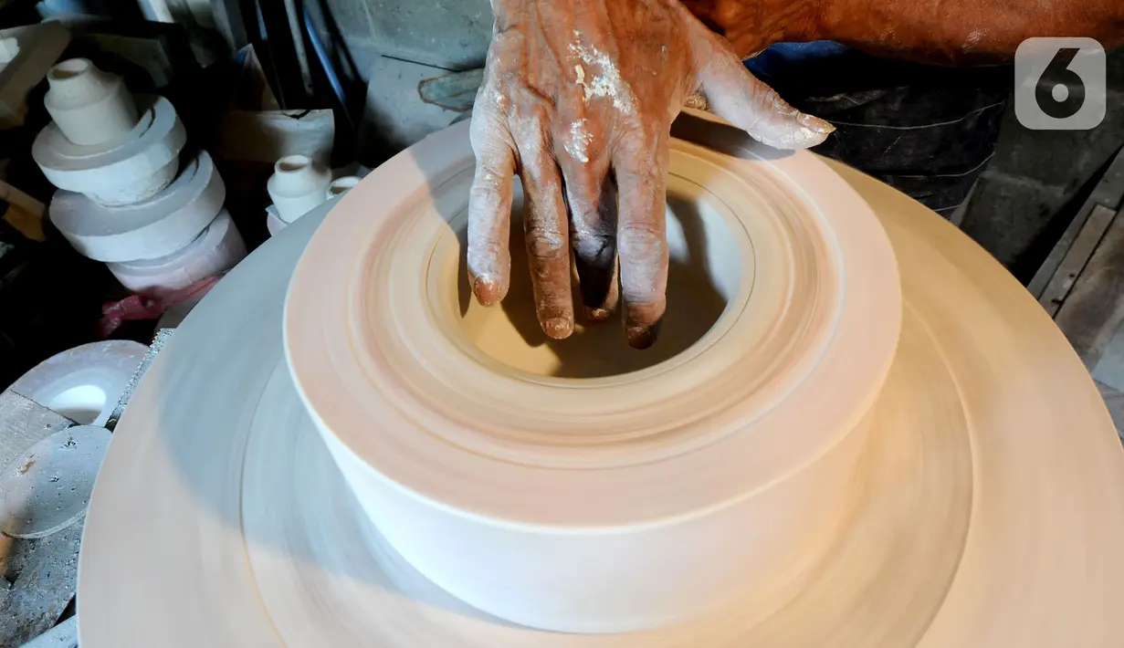 Perajin menyelesaikan pembuatan keramik secara handmade di Pekunden Pottery, Bojongsari, Depok, Jawa Barat, Rabu  (22/9/2021). Produksi keramik rumahan tersebut mampu bertahan di masa pandemi dengan mengandalkan jaringan offline dari mulut ke mulut. (merdeka.com/Arie Basuki)