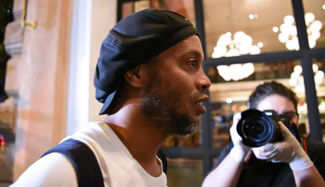Mantan pemain timnas Brasil, Ronaldinho tiba di sebuah hotel untuk menjalani tahanan rumah di Asuncion, Paraguay, Selasa (7/4/2020). Ronaldinho dan kakaknya dijebloskan ke penjara pada 5 Maret 2020 lantaran menggunakan paspor palsu saat masuk ke Paraguay. (Norberto DUARTE / AFP)