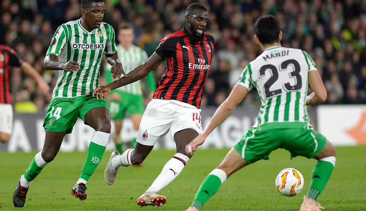 Gelandang AC Milan, Tiemoue Bakayoko berusaha melewati dua pemain Real Betis, issa Mandi dan William Carvalho selama pertandingan grup F Liga Europa di stadion Benito Villamarin, Sevilla (8/11). Milan menahan imbang Betis 1-1. (AFP Photo/Cristina Quicler)