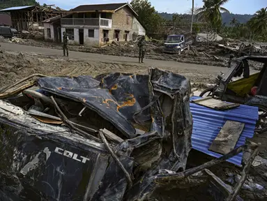 Dua personel Tentara Nasional Indonesia (TNI) membantu pemulihan lingkungan di kawasan permukiman yang terdampak banjir bandang di Desa Aek Garoga, Tapanuli Selatan, Sumatera Utara, pada Sabtu 27 Desember 2025. Upaya pemulihan pasca bencana di Desa Garoga, Kecamatan Batang Toru, Tapanuli Selatan, Sumatera Utara, terus berlangsung. (YT Hariono /AFP)