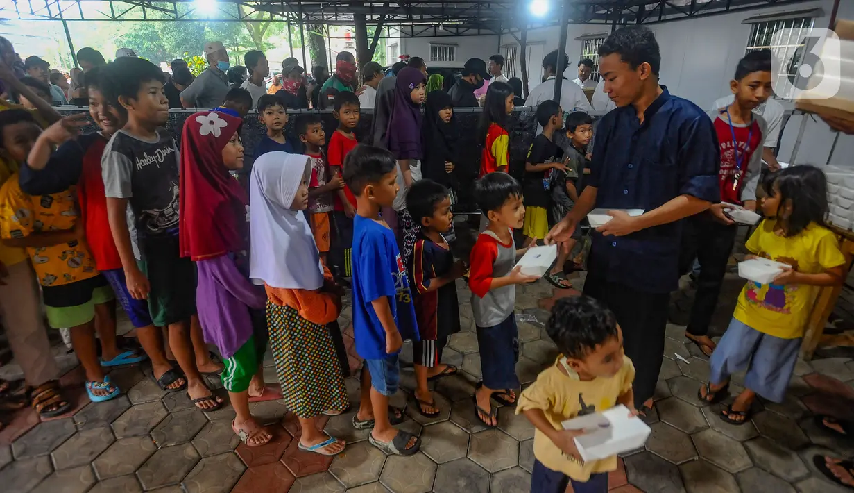 Anak-anak dan warga antre mendapatkan makanan pembuka puasa (takjil) di halaman Masjid Wihdatul Ummah, Limo, Depok, Senin (1/4/2024). (merdeka.com/Arie Basuki)