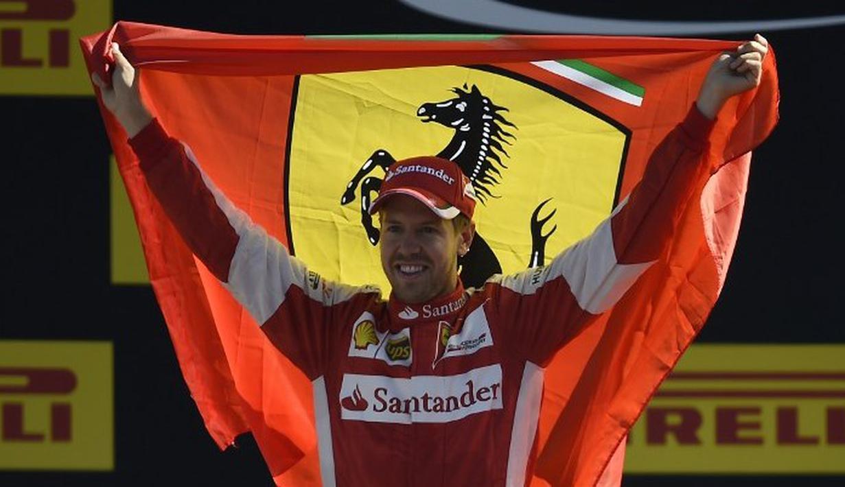Sebastian Vettel dengan bendera Ferrari di podium pemenang Sirkuit Monza, Italia. Minggu (6/9/2015). (AFP Photo/Olivier Morin)