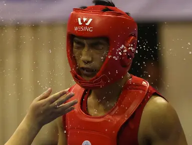 Atlet Wushu Asal China, menerima cipratan air dari pelatihnya pada nomor Sanda Kejuaraan Dunia Wushu 2015 di Istora, Senayan, Jakarta,Rabu (18/11/2015). (Bola.com/Nicklas Hanoatubun)