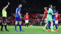 Wasit memberikan kartu merah kepada Idrissa Gueye usai terlibat pertengkaran dengan rekan setimnya Michael Keane di laga Everton kontra MU di Old Trafford. (Darren Staples / AFP)