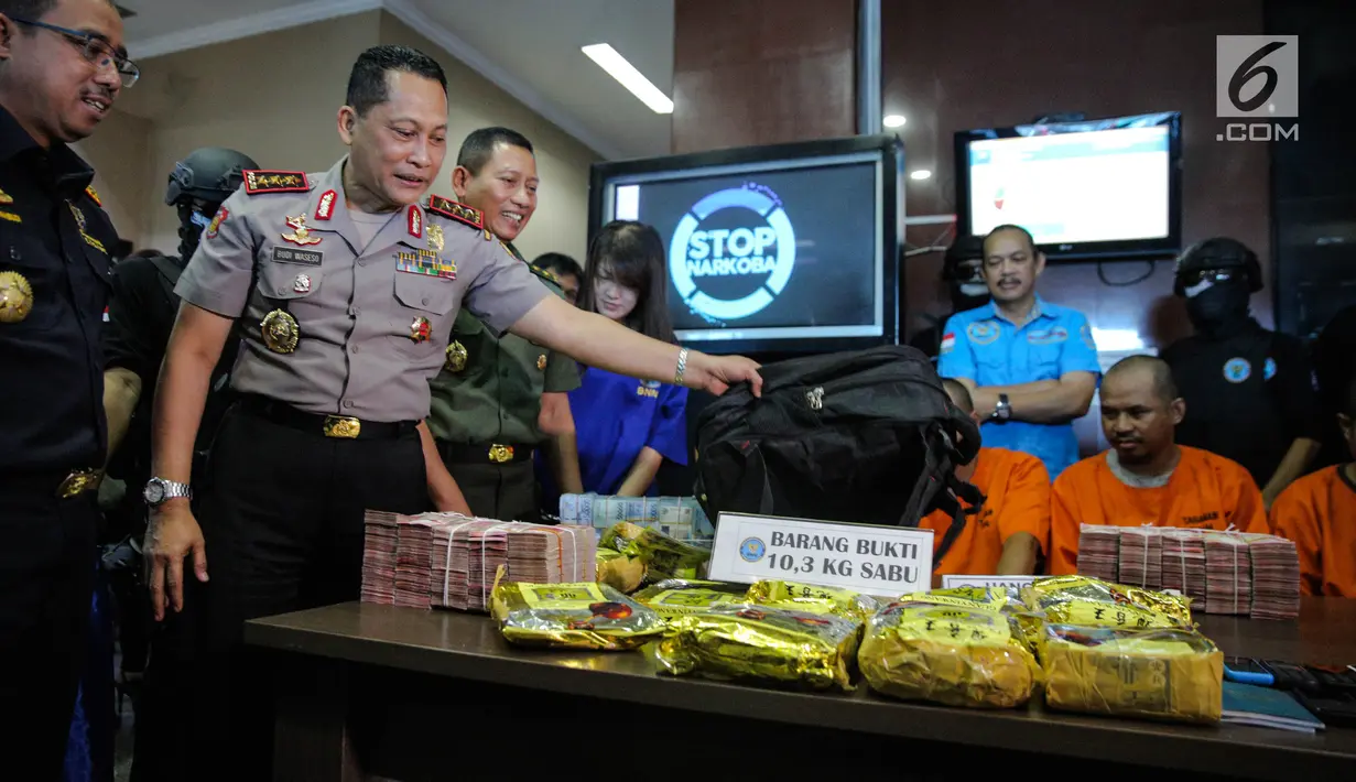 Kepala BNN, Komjen Pol Budi Waseso menunjukan barang bukti saat rilis penyelunduan narkotika di Gedung BNN, Jakarta, Selasa (12/9). Barang bukti sabu 10,39 Kg dan uang tunai sebanyak Rp. 1.650.000.000 diamankan. (Liputan6.com/Faizal Fanani)
