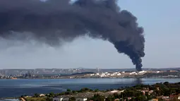 Kepulan asap hitam membumbung ke angkasa di kilang minyak milik perusahaan Amerika di Etang de Berre, Marseille, Perancis, (14/7/2015). kebakaran yang terjadi merupakan kebakaran terbesar kelima di Perancis. (REUTERS/Philippe Laurenson)
