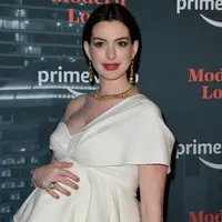 Aktris Anne Hathaway menghadiri pemutaran perdana "Modern Love," serial antologi romantis adaptasi dari rubrik New York Times di New York City, 10 Oktober 2019. Di karpet merah, Anne Hathaway memamerkan baby bump dalam balutan atasan model layer berwarna gading. (Angela Weiss / AFP)