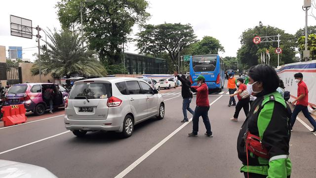 Komunitas ojek online (ojol) membantu mengatur arus lalu lintas di sekitar Gereja Katedral, Jakarta Pusat, Sabtu (25/12/2021).