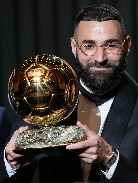 Pemain Real Madrid, Karim Benzema mengangkat trofi Ballon d'Or 2022 di Theater du Chatelet, Paris, Prancis, Senin (17/10/2022). Dalam persaingan trofi Ballon d'Or 2022, Benzema mengungguli Sadio Mane (Liverpool/Bayern Muenchen) dan Kevin De Bruyne (Manchester City). (AP Photo/Francois Mori)