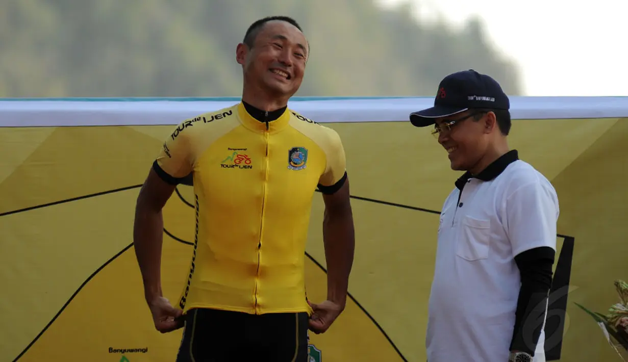Kyosuke Takei (kiri) mengenakan kaos kuning di podium kemenangan etape I balap sepeda International Tour de Banyuwangi Ijen, (16/10/2014). (Liputan6.com/Helmi Fithriansyah)
