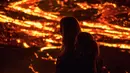 Orang-orang menyaksikan aliran lahar dari letusan gunung berapi di Semenanjung Reykjanes, barat daya Islandia, Senin (29/3/2021). Letusan gunung berapi tersebut tidak dipandang sebagai ancaman bagi kota-kota sekitar dan warga yang menyaksikan dari dekat. (AP Photo/Marco Di Marco)