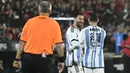 Lionel Messi (tengah) dan Maxi Rodriguez (kanan) saat bertanding memakai seragam Timnas Argentina dalam acara pertandingan perpisahan Maxi Rodriguez sebagai pesepak bola profesional yang diselenggarakan di Marcelo Bielsa Stadium, Argentina, Minggu (25/6/2023). (AFP/Stringer)