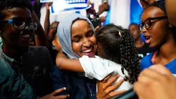 Ilhan Omar memeluk anaknya saat merayakan kemenangan putaran pertama pemilihan Distrik Kongres ke-5 di Minneapolis, AS, Selasa (14/8). Omar segera menggantikan posisi Keith Ellison dari kursi perwakilan rakyat. (Mark Vancleave/Star Tribune via AP)