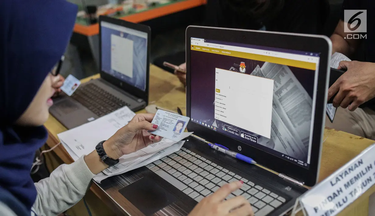 Petugas membantu warga yang mengurus formulir A5 atau surat pindah memilih di Kantor KPU Kota Jakarta Pusat, Minggu (17/2). KPU membagi layanan pengurusan pindah memilih menjadi dua tahap untuk menghindari penumpukan. (Liputan6.com/Faizal Fanani)