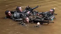Tentara dari Combat Team Divisi Infanteri 1 Stryker Brigade Angkatan Darat AS menyusuri sungai dalam pelatihan perang hutan di Hawaii, 1 Maret 2017. Tentara Angkatan Darat melakukan kursus pelatihan hutan untuk fokus pada Asia dan Pasifik. (AP/Daniel Lin)