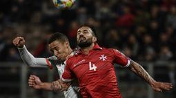 Duel udara dilakukan Steve Borg dan penyerang Spanyol. Rodrigo pada laga kedua Kualifikasi Piala Eropa 2020 yang berlangsung di Stadion Ta Qali, Malta, Rabu (27/3). Spanyol menang 2-0 atas Malta. (AFP/Filippo Monteforte)
