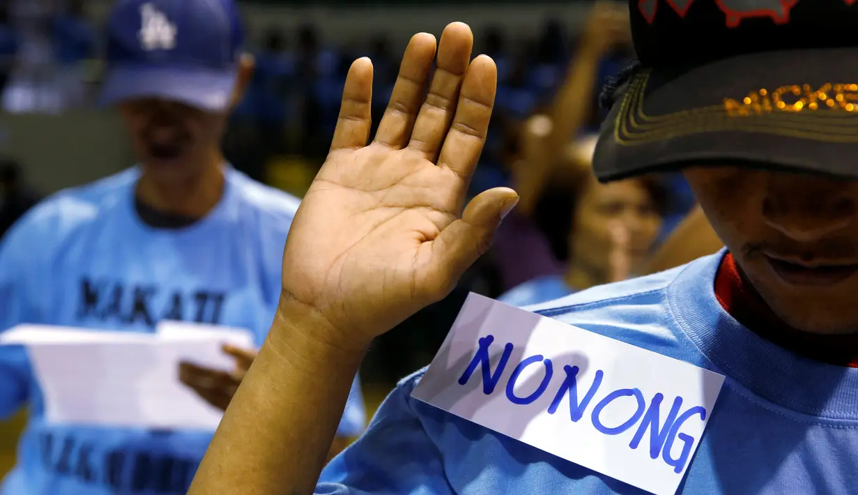 Pecandu narkoba mengambil sumpah saat bertobat di depan kepolisian di Makati, Manila, Filipina (18/8). Para pecandu narkoba menyerahkan diri lantaran marak teror penembakan misterius di Filipina. (Reuters/Eric Castro)