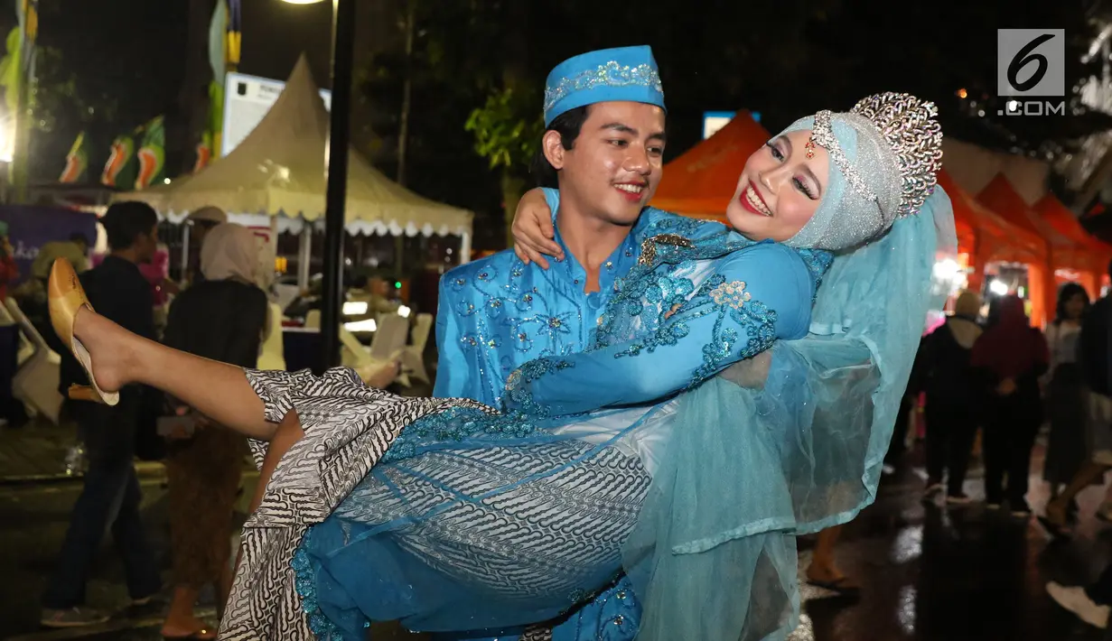 Pasangan Hendrik dan Leonita Wulandari meluapkan kebahagiaan usai ijab kabul di jalan MH Thamrin, Jakarta, Senin (31/12). 557 pasangan mengikuti nikah massal dan isbat nikah pada malam pergantian tahun 2018-2019. (Liputan6.com/Helmi Fithriansyah)