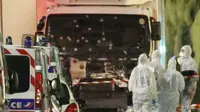 Polisi dan petugas forensik berdiri di samping truk yang menabrak puluhan warga saat merayakan Bastille Day di Nice, Prancis (Reuters)