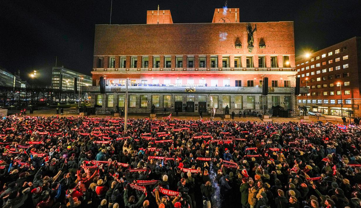 Puluhan ribu orang berkumpul di depan balai kota Oslo saat menyambut para pemain dan staf pelatih Norwegia. Mereka merayakan keberhasilan Norwegia lolos ke Piala Dunia 2026 sekaligus mengakhiri penantian selama 28 tahun. (Heiko Junge/NTB via AP)