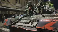 Anggota kompi militer Wagner Group duduk di atas sebuah tank di jalan di Rostov-on-Don, Rusia, Sabtu, 24 Juni 2023, sebelum meninggalkan area markas militer Rusia. (AP)