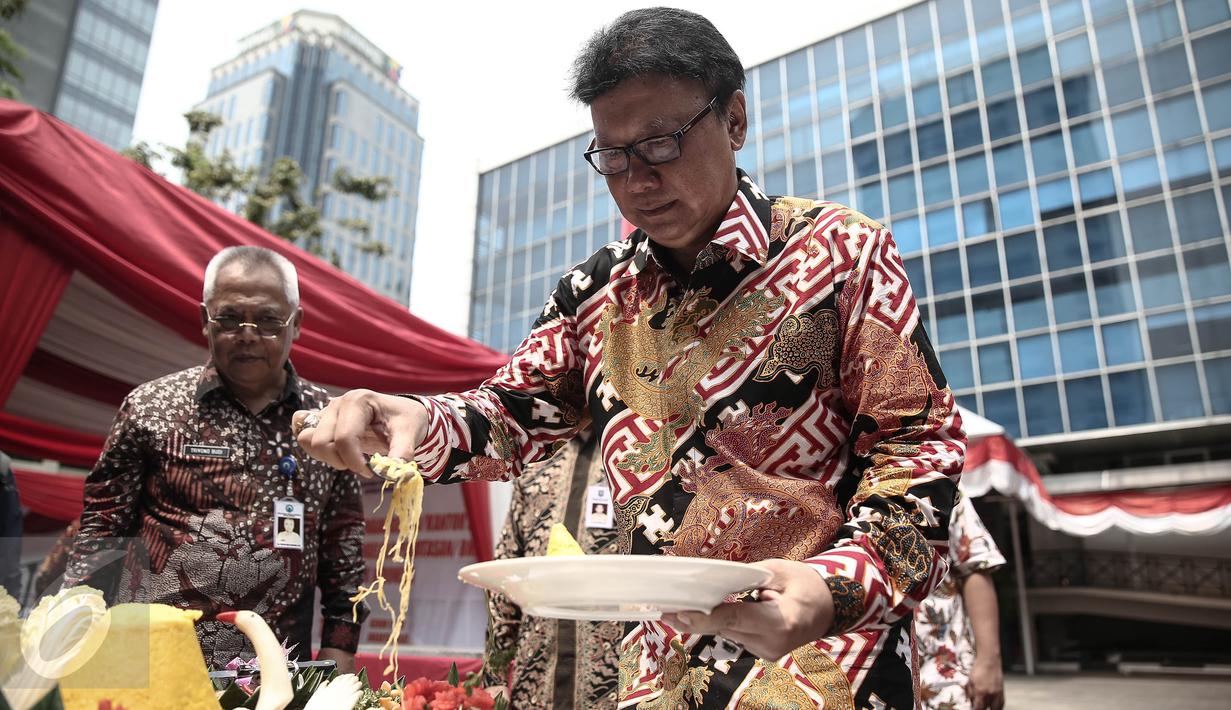 Mendagri Tjahjo Kumolo mengambil nasi tumpeng pada peresmian Kantor Badan Nasional Pengelola Perbatasan (BNPP) di Jakarta, (19/5). BNPP merupakan lembaga yang bertanggung jawab mengkordinasikan pengelolaan perbatasan negara. (Liputan6.com/Faizal Fanani)