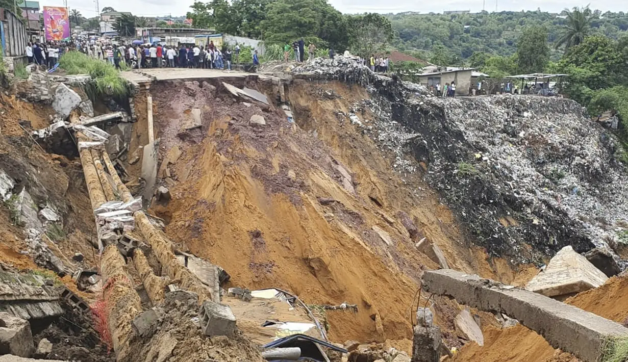 Permukaan jalan ambruk oleh tanah longsor yang disebabkan hujan lebat melanda distrik Lemba, Kinshasa di Republik Demokratik Kongo pada Selasa (26/11/2019). Musibah tersebut telah mengakibatkan jalan raya yang menjadi penghubung antar desa putus total. (AFP/Ange Kasongo)