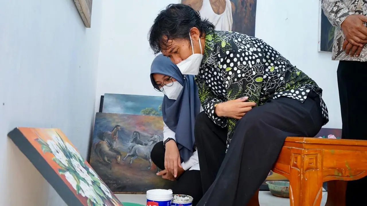 Lukman Hakim (29), pelukis difabel asal Desa Singolatren, Kecamatan Singojuruh, Kabupaten Banyuwangi. (Dian Kurniawan/Liputan6.com)