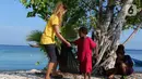 Aktivis AS, Carrie dan anak-anak membersihkan sampah plastik di bibir pantai Desa Sawandarek, Raja Ampat, Papua Barat (22/11/2019). Aksi membersihkan sampah plastik ini, digagas Carrie, aktivis asal Amerika Serikat,  yang sudah menetap di Indonesia selama 3 tahun. (Liputan6.com/Herman Zakharia)