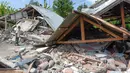 Warga memeriksa bangunan rumah yang roboh akibat gempa yang melanda Lombok, NTB, Minggu (29/7). Data sementara BPBD Provinsi NTB mencatat, gempa bumi tektonik 6.4 SR itu mengakibatkan 10 orang meninggal dunia dan puluhan rumah rusak. (AFP/Aulia AHMAD)