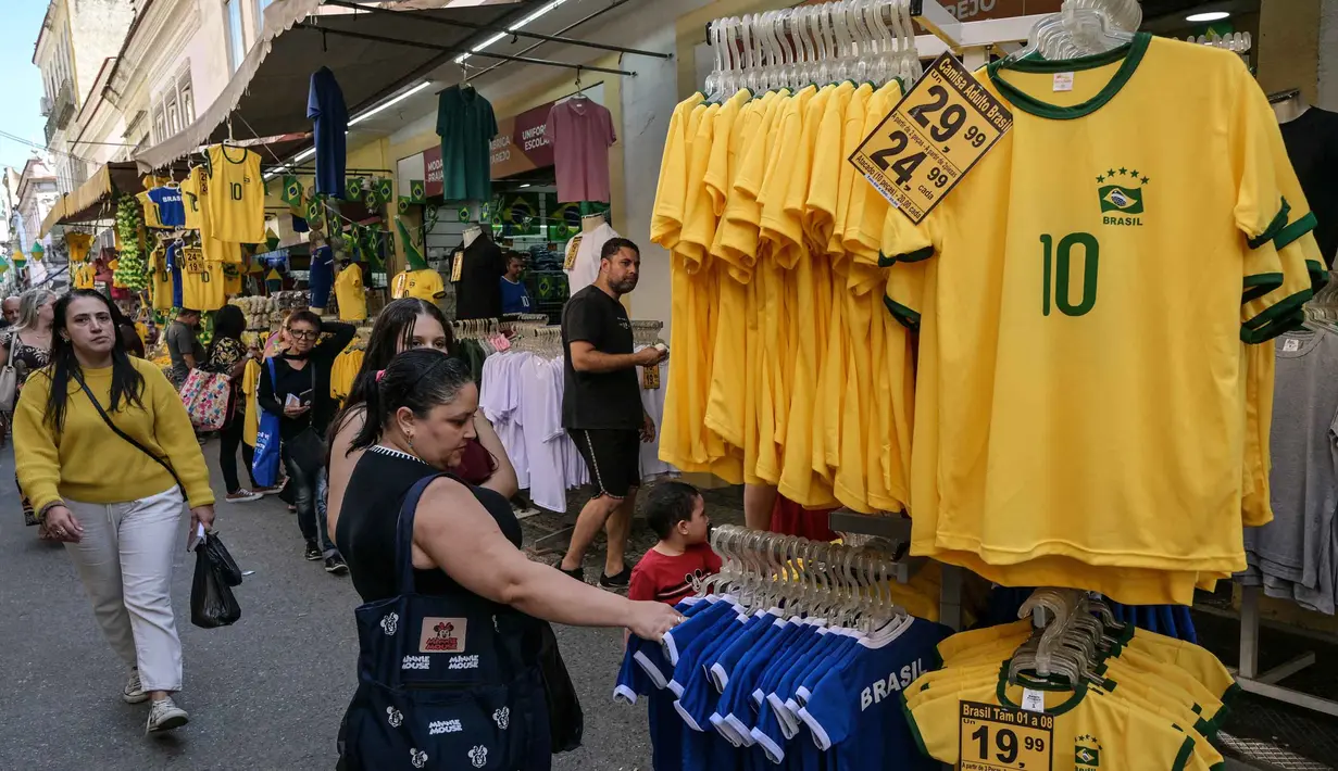 Seorang penggemar sepak bola Brasil melihat-lihat jersey tim nasional sepak bola yang dipajang di pasar Saara, Rio de Janeiro, Brasil, pada Selasa 9 Juni 2026, menjelang turnamen Piala Dunia FIFA 2026. (Nelson ALMEIDA/AFP)