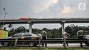 Petugas kepolisian saat berjaga di sekitar lokasi tabrakan kereta Light Rail Transit (LRT) di kawasan Munjul, Cibubur, Jakarta, Senin (25/10/2021). Dua rangkaian kereta LRT Jabodebek mengalami tabrakan saat tengah menjalani tahap uji coba pada pukul 12.30 WIB. (merdeka.com/Iqbal S Nugroho)
