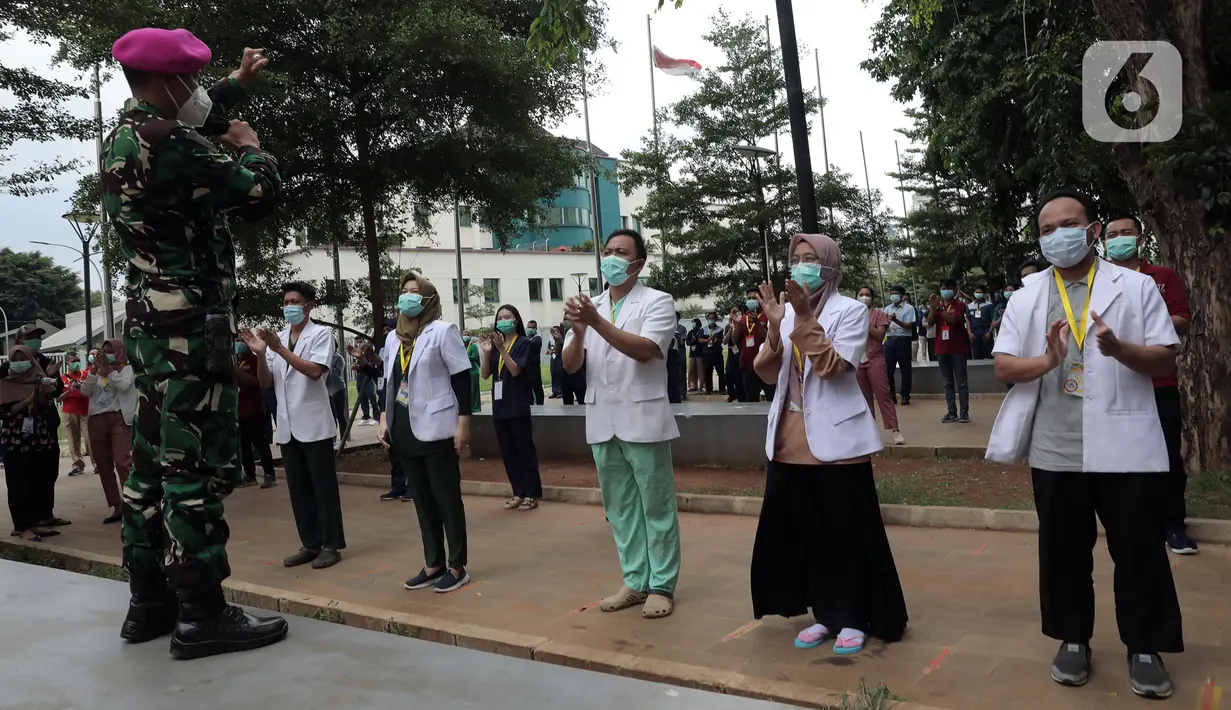 Tenaga kesehatan dan nonkesehatan bertepuk tangan selama 56 detik pada peringatan Hari Kesehatan Nasional ke-56 di RSD Wisma Atlet, Jakarta, Kamis (12/11/2020). Aksi tersebut sebagai bentuk penghargaan kepada tenaga kesehatan yang berjuang menghadapi pandemi COVID-19. (Liputan6.com/Herman Zakharia)