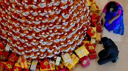 Staff menyusun bingkisan kado di bawah pohon Natal dari boneka beruang teddy di lobi sebuah hotel di Bangalore, India, Rabu (28/11). Ratusan boneka beruang disusun sedemikian rupa hingga membentuk pohon natal cantik. (MANJUNATH KIRAN / AFP)