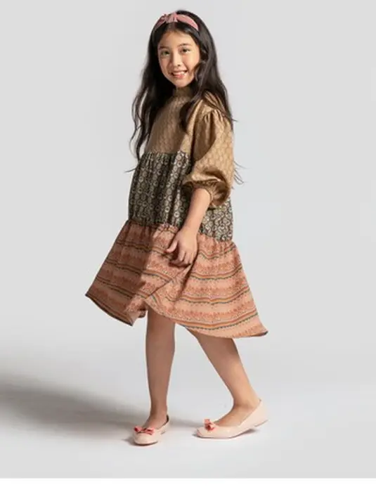 KAMI menawarkan pakaian muslim bagi anak-anak dengan desain yang nyaman untuk digunakan bermain bersama di rumah. Salah satunya seperti Kiya Dress Kids Light Sand./ Foto: Zalora.