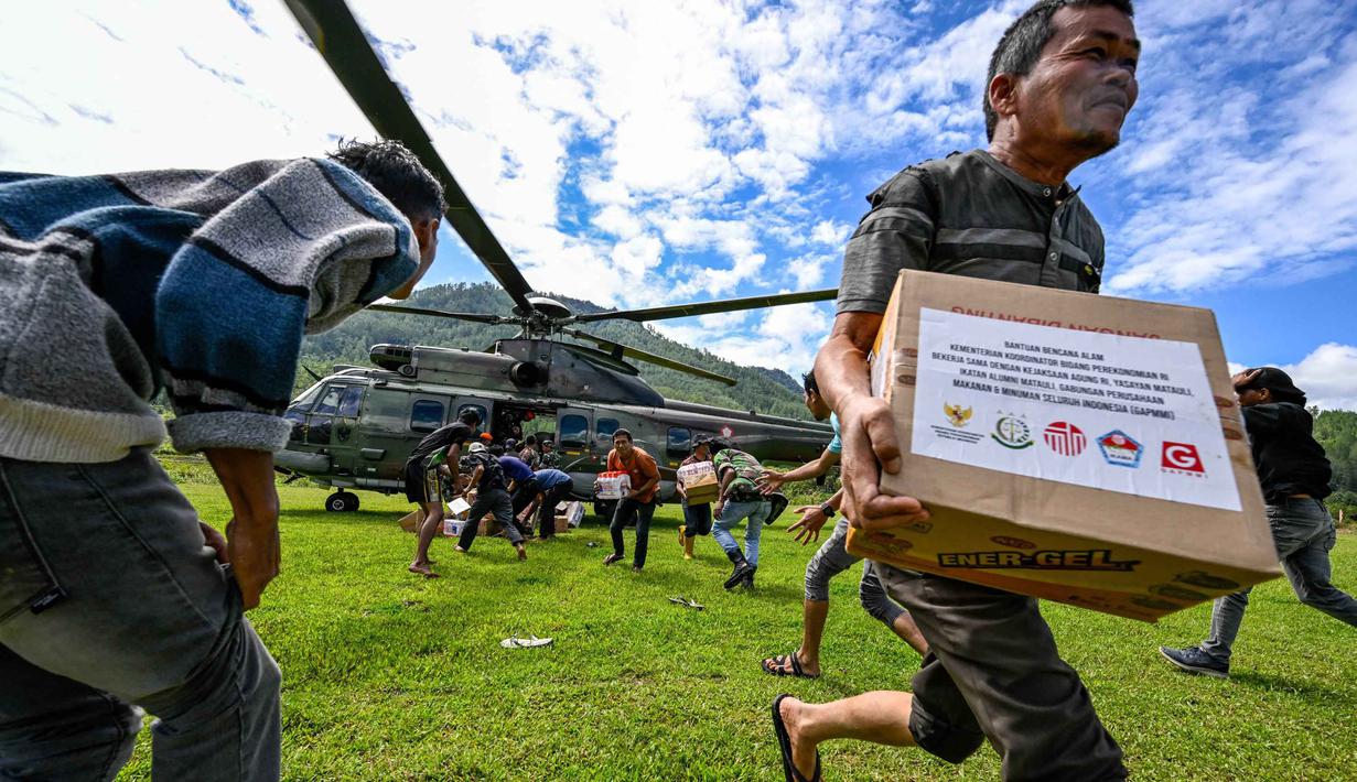 Sebelumnya, Badan Nasional Penanggulangan Bencana (BNPB) mengungkap, distribusi bantuan ke empat kabupaten di Provinsi Aceh masih sulit ditempuh lewat jalur darat. Tampak dalam foto, warga membawa bantuan yang didistribusikan oleh personel TNI AU di wilayah terdampak banjir di Kabupaten Bener Meriah, Provinsi Aceh, pada Kamis 4 Desember 2025. (CHAIDEER MAHYUDDIN/AFP)