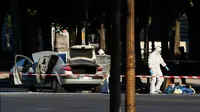 Tim penyelidik forensik melakukan olah TKP lokasi serangan di kawasan Champs Elysees, Paris, Senin (19/6). Seorang pria yang diduga terkait dengan ekstrimis menabrakkan mobilnya ke arah mobil van polisi di jalanan ikonik itu. (AP Photo/Matthieu Alexandre)