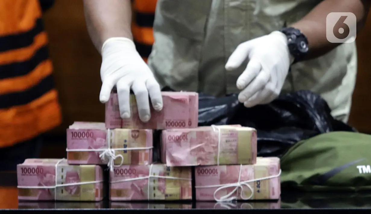 Petugas menunjukkan barang bukti hasil OTT Bupati Langkat, Terbit Rencana Perangin Angin saat rilis penahanan tersangka di Gedung KPK, Jakarta, Kamis (20/1/2022). KPK resmi menahan Bupati Langkat, Terbit Rencana Perangin Angin dan menyita uang sebesar Rp 786 juta. (Liputan6.com/Helmi Fithriansyah)