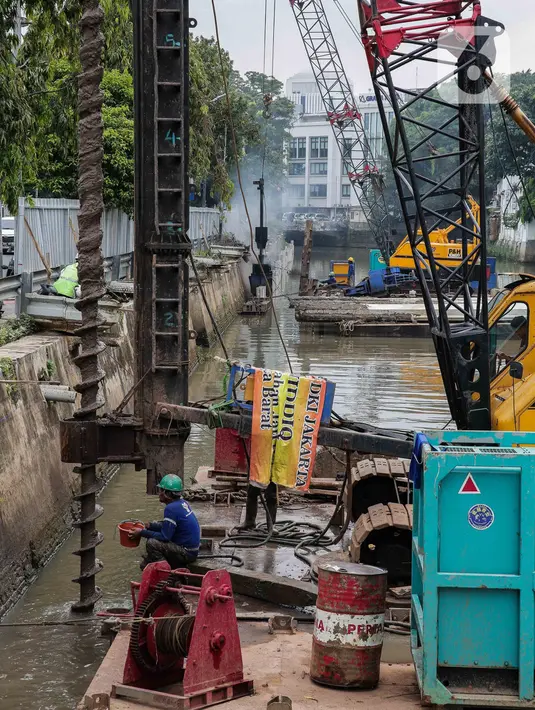 Pekerja menyelesaikan pemasangan dinding turap di kali pasar baru, Jakarta, Rabu (9/3/2022). Dinas Sumber Daya Air DKI Jakarta melakukan pemasangan turap bertujuan untuk mengantisipasi banjir serta tanah ambles di pinggir sungai. (Liputan6.com/Faizal Fanani)