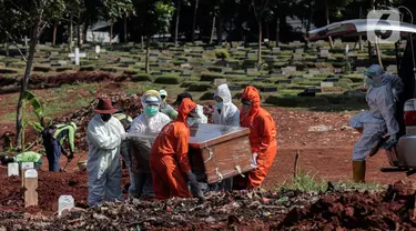 Petugas Suku Dinas Pertamanan dan Pemakaman mengenakan perlengkapan APD memakamkan jenazah pasien COVID-19 di TPU Pondok Rangon, Jakarta, Rabu (17/6/2020). (Liputan6.com/Johan Tallo)