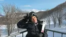 Dalam foto lain, Naysila tampak sedang berpose dengan perlengkapan ski lengkap. Ia mengenakan jaket tebal warna hitan, sarung tangan, dan helm ski. Dengan latar pegunungan bersalju dan langit biru cerah, aura sporty dan fun sangat terasa. Tak hanya menunjukkan gaya fashion musim dingin yang keren, namun juga semangat petualangan yang menginspirasi. [@naymirdad].