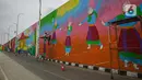 Pekerja menyelesaikan pembuatan mural di Flyover Gaplek, Tangerang Selatan, Rabu (10/3/2021). Konsep muralnya adalah "Tangsel Membangun". (Liputan6.com/Faizal Fanani)