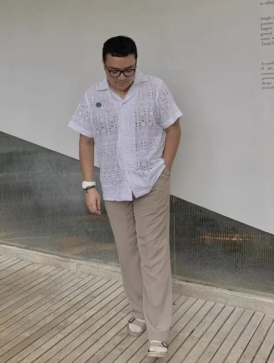 Ia pun tampil casual dengan kemeja putih dan aksesori bros. Dipadu drngan pants cokelat mudanya. Untuk alas kaki, ia memilih mengenakan kaos kaki dan sandal. (@geofannytambunan)